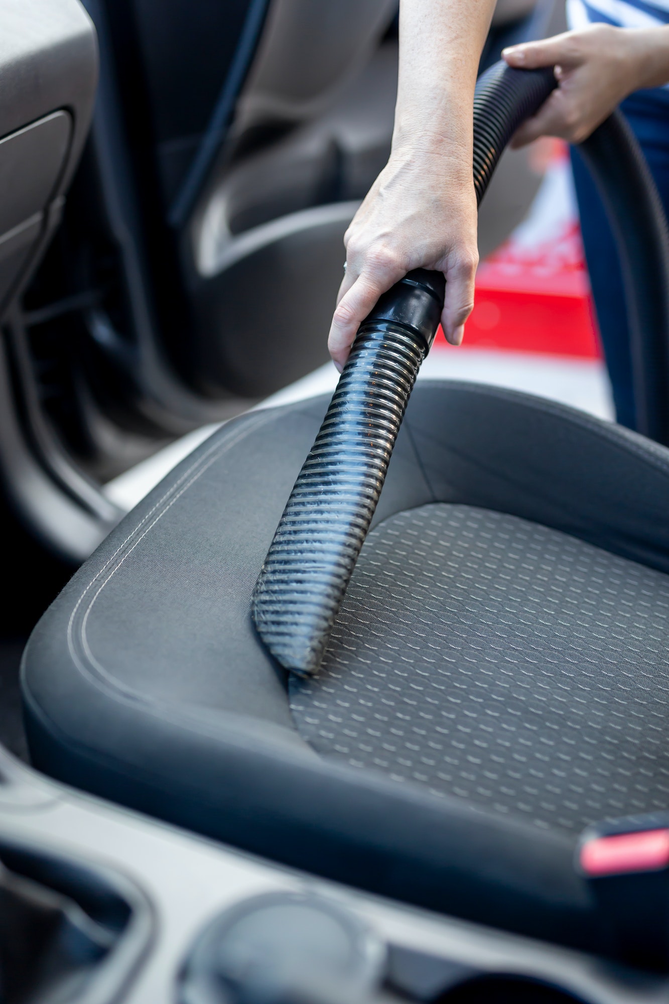 Woman vacuuming car seats